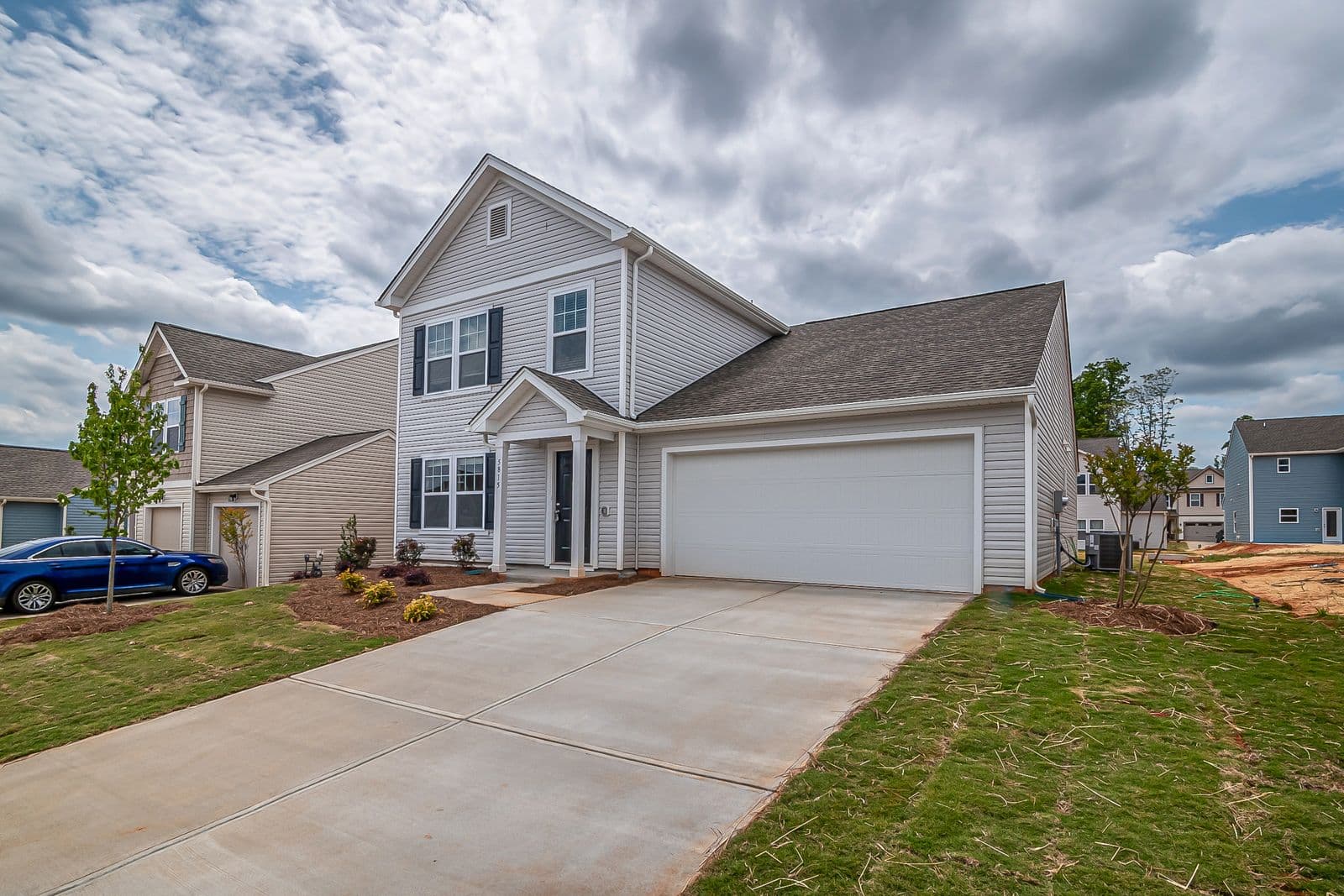 Modern two-story suburban home with a landscaped front yard — sellers preparing to list